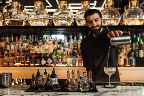 a man standing behind a bar making a drink at Jackalope Hotel in Merricks North