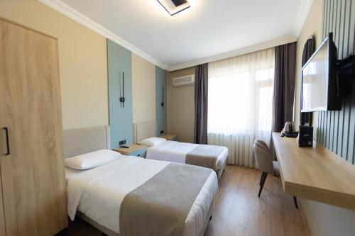 a hotel room with two beds and a television at Otel 57 in Sinop