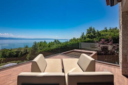 a view from the balcony of a house with a table and chairs at Villa AltaVista - Seaview & Relax with Heated Pool & MiniGolf in Opatija
