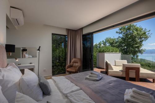 a bedroom with a bed and a large window at Villa AltaVista - Seaview & Relax with Heated Pool & MiniGolf in Opatija