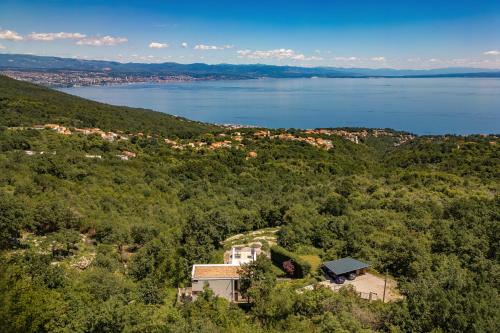 an aerial view of a house on a hill next to a lake at Villa AltaVista - Seaview & Relax with Heated Pool & MiniGolf in Opatija
