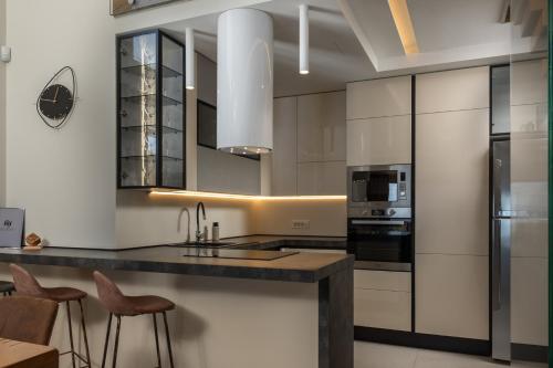 a kitchen with white cabinets and black countertops at Villa AltaVista - Seaview & Relax with Heated Pool & MiniGolf in Opatija
