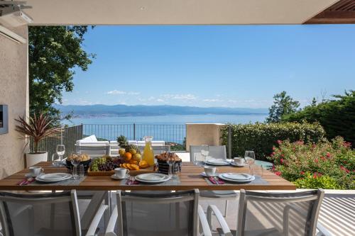 a table on a patio with a view of the water at Villa AltaVista - Seaview & Relax with Heated Pool & MiniGolf in Opatija