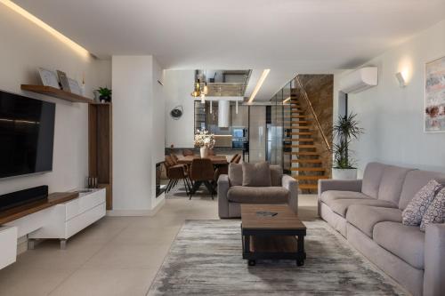 a living room with a couch and a tv at Villa AltaVista - Seaview & Relax with Heated Pool & MiniGolf in Opatija