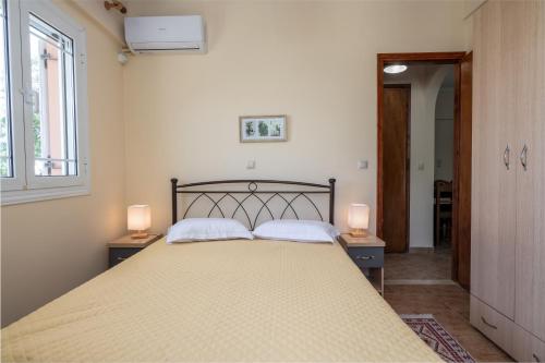 a bedroom with a large bed with two lamps at Maria's Sea View Apartments in Mousata