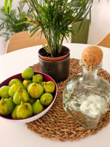 a bowl of green limes and a bottle on a table at Robinson House Mimo in Neviđane