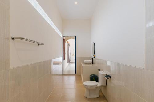 een witte badkamer met een toilet en een wastafel bij Arjuna Villa by Betterplace in Dalung