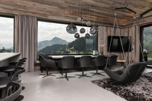 a dining room with a table and chairs and a large window at GOING TRIPLE A apartments EAST in Going