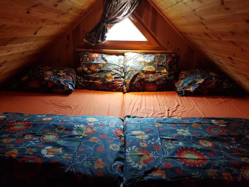 a room with a bed and pillows in a attic at Wyspa Świerków in Lipusz
