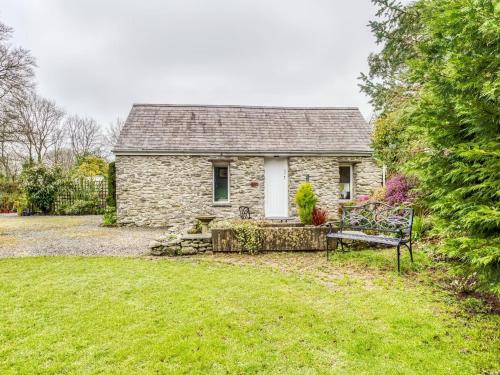 a stone house with a bench in front of it at Secluded Holiday Home in Ceredigion with Garden in Pennant
