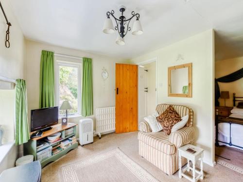 a living room with a couch and a tv at Secluded Holiday Home in Ceredigion with Garden in Pennant
