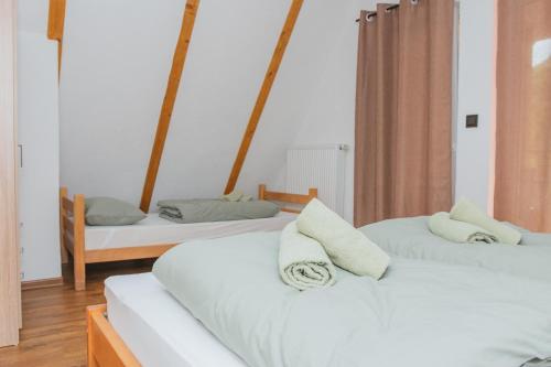 two beds in a room with white sheets and pillows at UnaSoul in Bihać