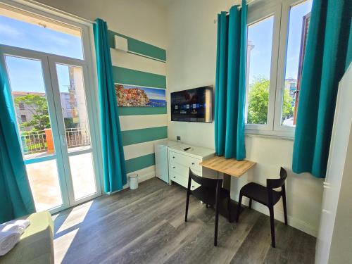a room with a desk and a table with chairs at Affittacamere Guest House Happy Holiday in La Spezia