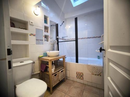 a bathroom with a toilet and a sink and a tub at Maison des Remparts nichée sous la Cité in Carcassonne