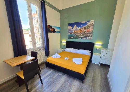 a bedroom with a bed and a table and a desk at Affittacamere Guest House Happy Holiday in La Spezia