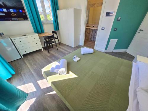 a room with a bed and a table with towels at Affittacamere Guest House Happy Holiday in La Spezia