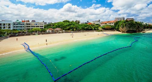 an aerial view of a beach with people in the water at HOTEL SANSUI NAHA Ryukyu Onsen Naminoue-No-Yu in Naha