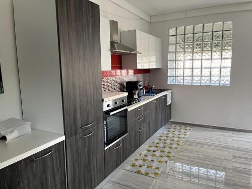 a kitchen with wooden cabinets and a stove top oven at 'C'est la vie' Apartment VR20 in Gela
