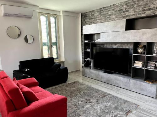a living room with a red couch and a fireplace at 'C'est la vie' Apartment VR20 in Gela