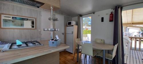 - une cuisine avec un comptoir, une table et une cuisinière dans l'établissement Mobilhome 4 personnes 2 chambres Camping 3 étoiles Ivry la Bataille, à Ivry-la-Bataille