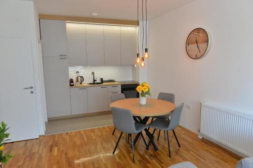 a kitchen and dining room with a table and chairs at HM Apartments in Inđija
