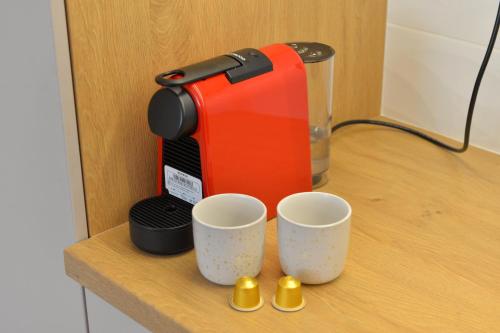 a coffee maker sitting on a counter with two cups at HM Apartments in Inđija