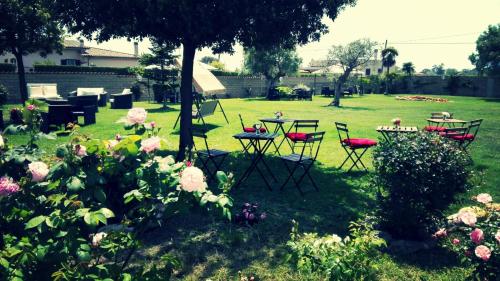 a garden with a table and chairs and flowers at Villa Elegance in Ladispoli