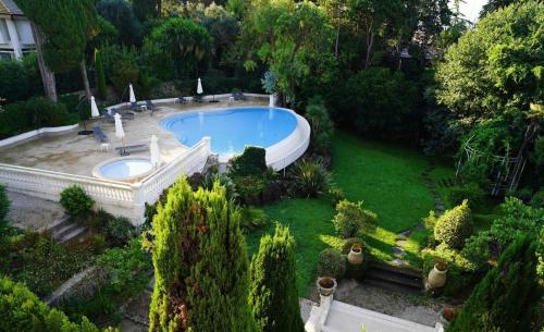 - une vue sur le jardin et la piscine dans l'établissement Charlotte piscine parking, à Cannes