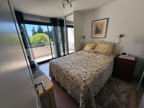 une chambre avec un lit et une grande fenêtre dans l'établissement Charlotte piscine parking, à Cannes