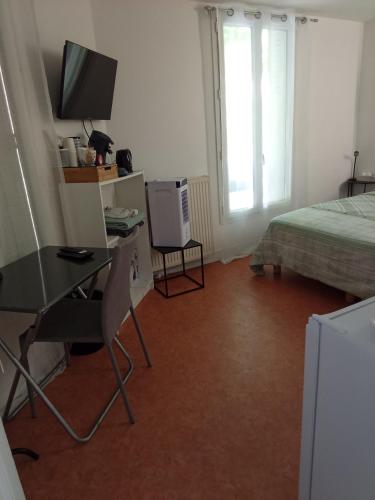 a bedroom with a desk and a bed and a television at Chambre privée a Arcueil - Cachan in Cachan