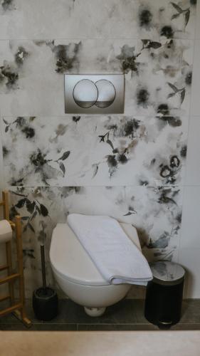 a bathroom with a toilet and a black and white wall at Jakova Hiša in Kobarid