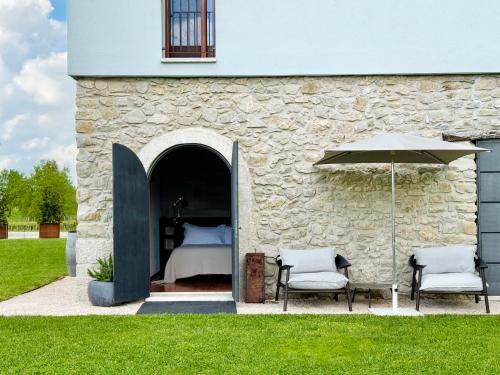 a bed in a building with two chairs and an umbrella at Borgo San Gregorio in Sorbo Serpico
