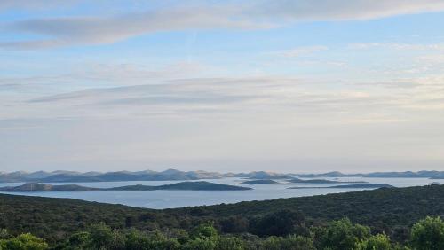 a view of a lake with mountains in the distance at Robinson House Mimo in Neviđane