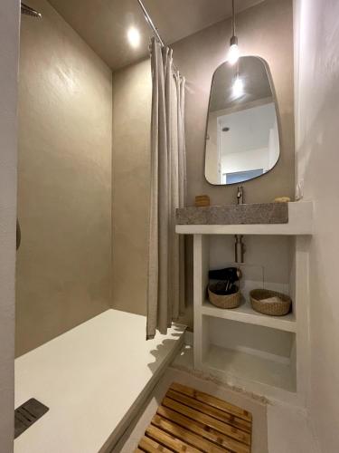 une salle de bain avec un lavabo et un miroir dans l'établissement Charmant appartement avec terrasse à deux pas de l'océan, à Hourtin