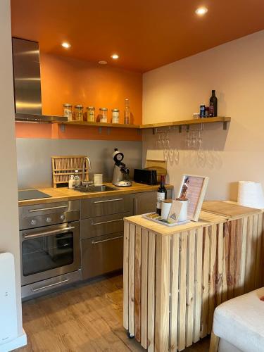 une cuisine avec un îlot en bois au milieu dans l'établissement Charmant appartement avec terrasse à deux pas de l'océan, à Hourtin