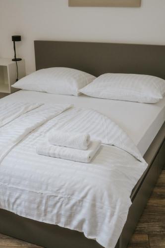 a white bed with two folded towels on it at Jakova Hiša in Kobarid