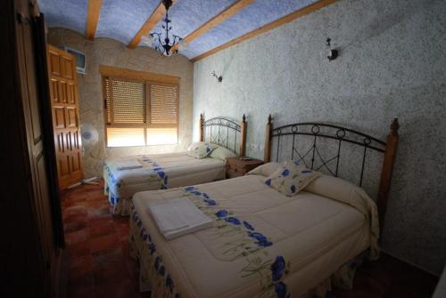 a bedroom with two beds and a window at Alojamientos Rio Zumeta in El Morrion
