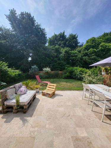 un patio avec un canapé, une table et des chaises dans l'établissement Chambre chez l'habitant, au Mans