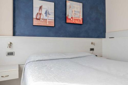 a bedroom with three pictures hanging above a bed at Hotel POSTA - 2 stars - Comfortable Stay in Ventimiglia in Ventimiglia