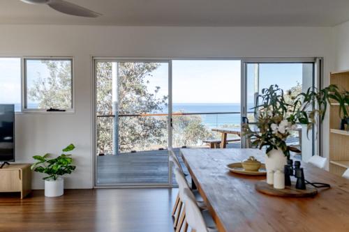 a dining room with a table with a view of the ocean at The Bermuda - Oceanview Luxury in Ulladulla