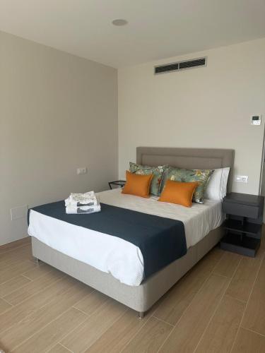 a bedroom with a large bed with orange pillows at Alojamientos Ría de Vigo & Alborada in Moaña