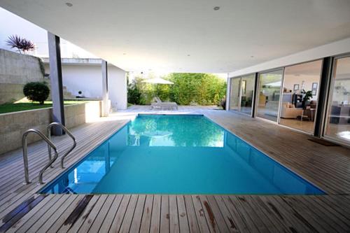 una piscina en una casa con terraza de madera en Villa 257, en Caminha
