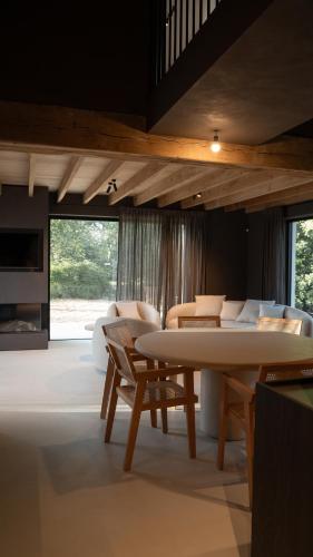 ein Wohnzimmer mit einem weißen Tisch und Stühlen in der Unterkunft Meme Wiesje in Oudenburg