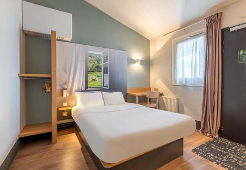 a bedroom with a large white bed and a window at B&B HOTEL Dieppe in Saint-Aubin-sur-Scie
