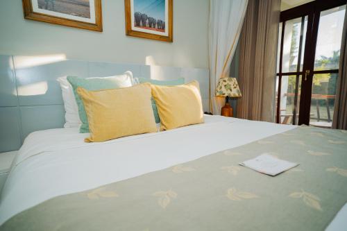a bedroom with a large white bed with yellow pillows at Arusha Planet Lodge in Arusha