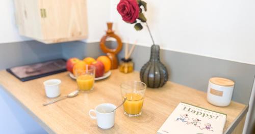 une table avec deux verres de jus d'orange et une assiette de fruits dans l'établissement Hypercenter - Haven of peace near Corps Saints, à Avignon