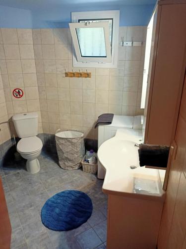 ein Badezimmer mit einem weißen Waschbecken und einer Toilette in der Unterkunft The Vrachos Beach House in Preveza