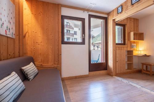 Una sala de estar con un sofá y una ventana. en Joli appartement Aiguille du Midi, en Chamonix-Mont-Blanc