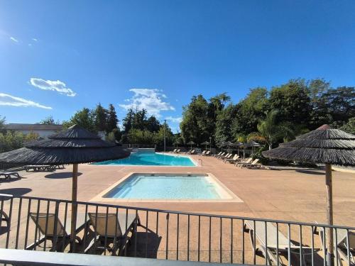 - une piscine avec des chaises et des parasols dans un complexe dans l'établissement bel appartement avec jardin, à Poggio-Mezzana
