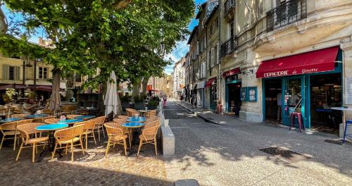 un café en plein air avec des tables et des chaises dans une rue de la ville dans l'établissement Hypercenter - Haven of peace near Corps Saints, à Avignon